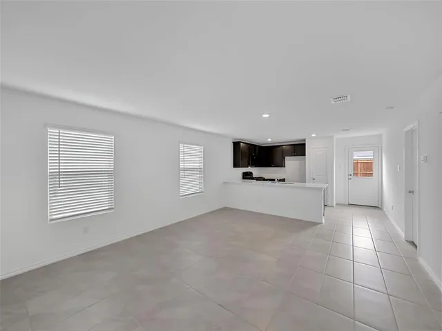 a view of empty room with a kitchen