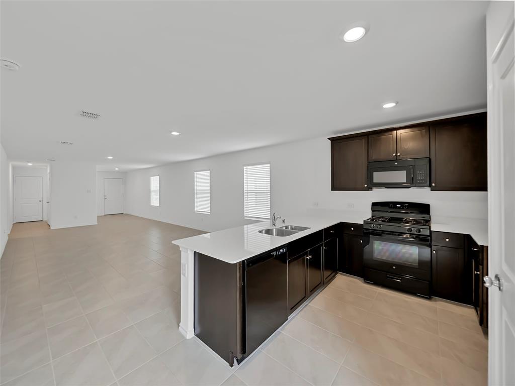 7765 Ruellia Road McKinney, TX 75071 - Photo 40 of 40 a kitchen with stainless steel appliances granite countertop a sink stove and refrigerator