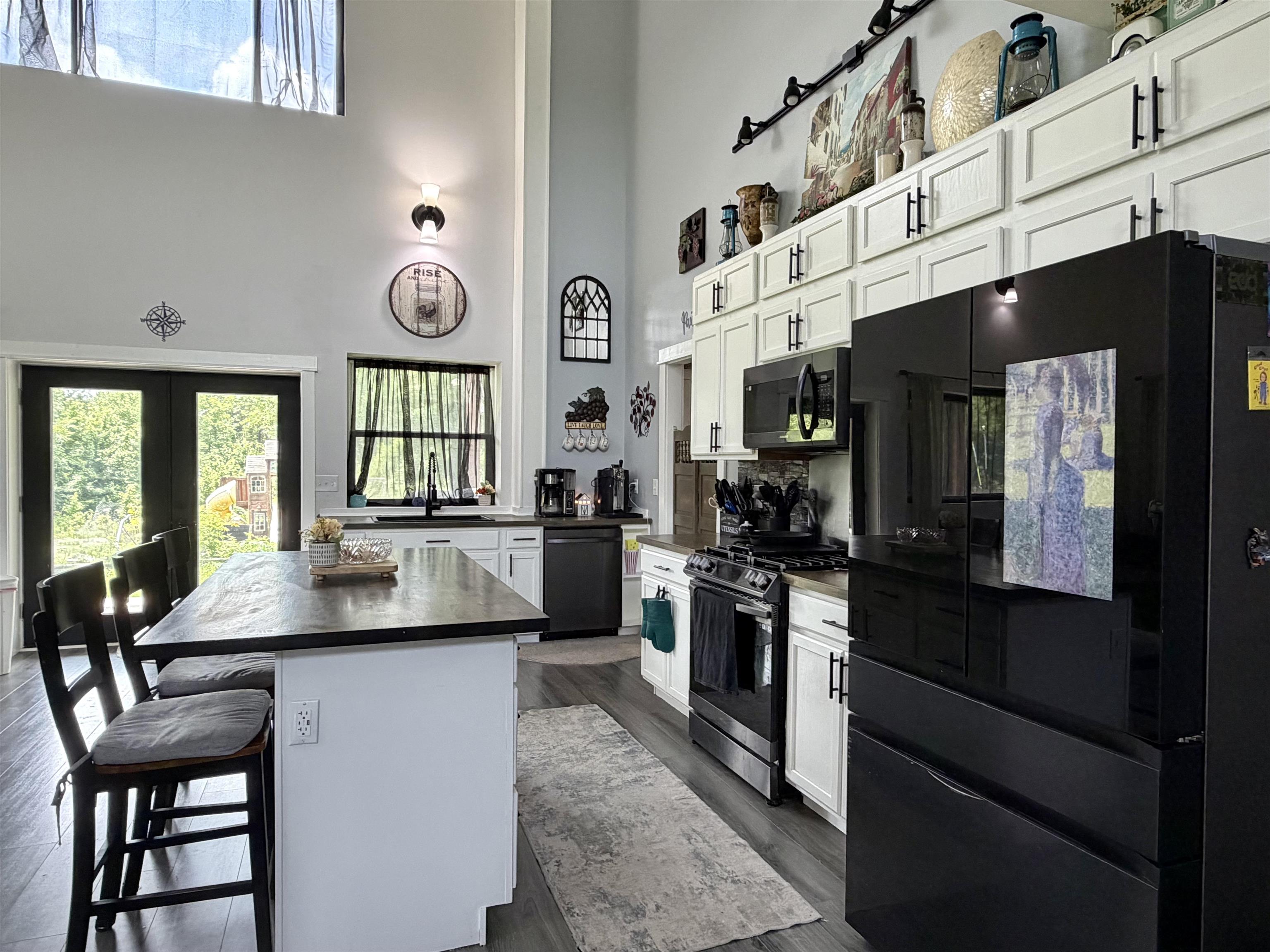 3670 Peavine Road Middleton, TN 38052 - Photo 6 of 36 Kitchen featuring a black appliance suite, white cabinetry with black hardware, and wood-finish flooring