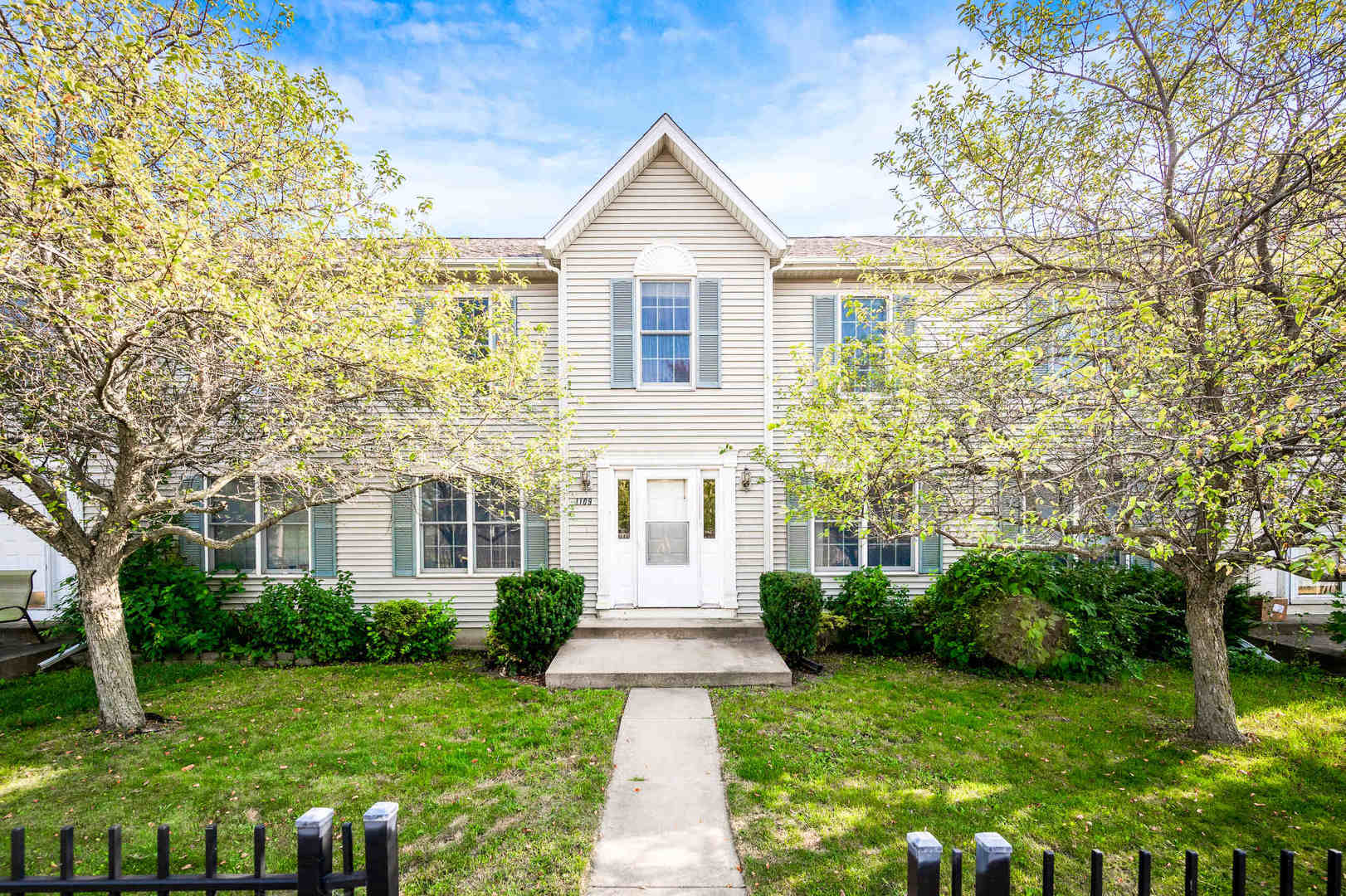 a front view of a house with a garden and yard