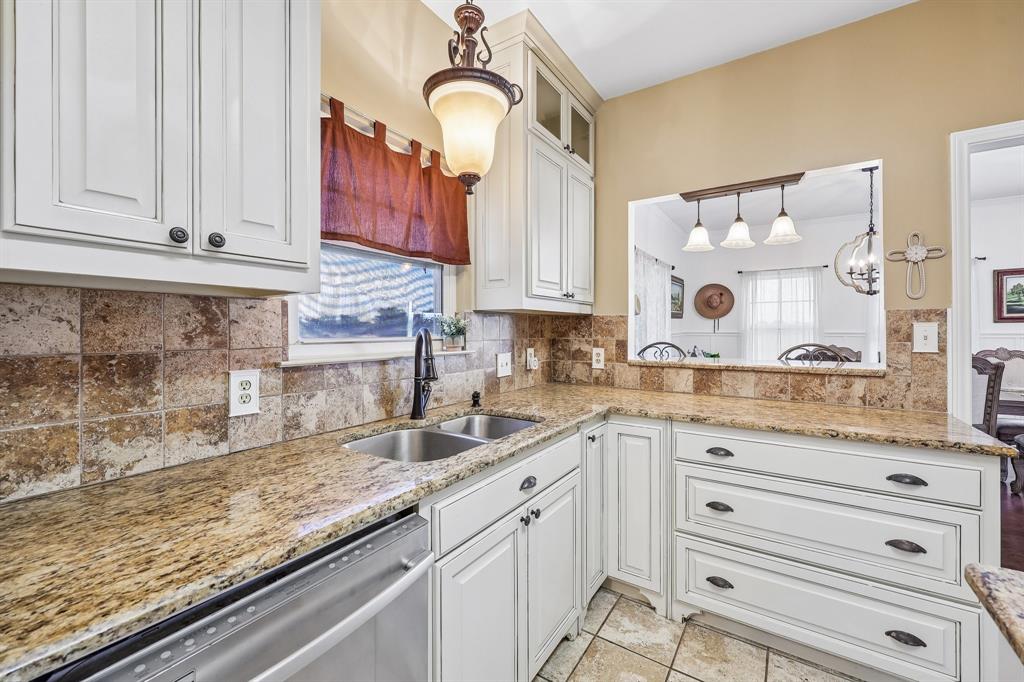 331 Radecke Road Krum, TX 76249 - Photo 20 of 40 Kitchen featuring light cabinetry, a double basin sink with a gooseneck faucet, light granite countertops, and a stone tile backsplash