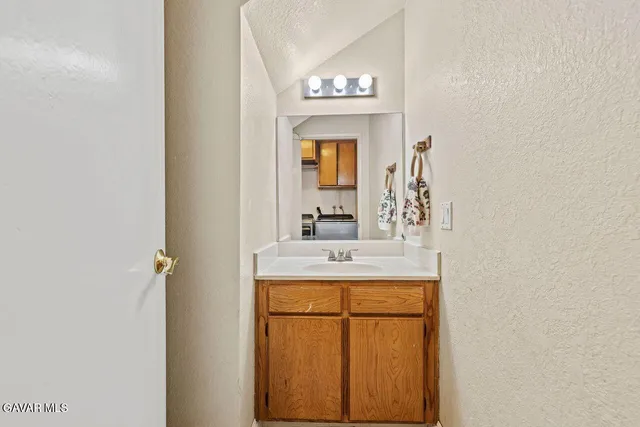 a bathroom with a granite countertop sink and a mirror