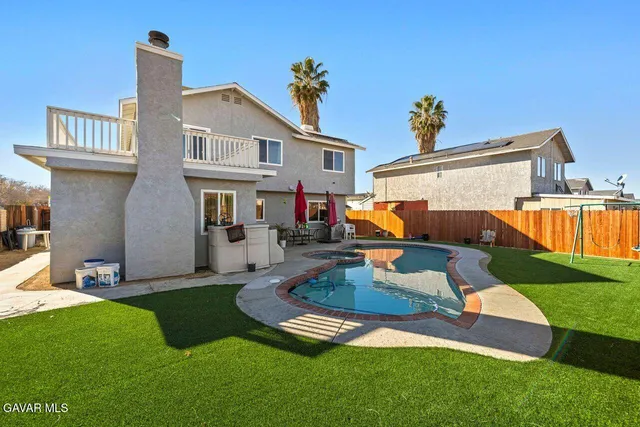 a front view of a house with swimming pool having outdoor seating
