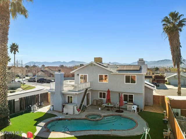 a front view of a house with a garden and lake view