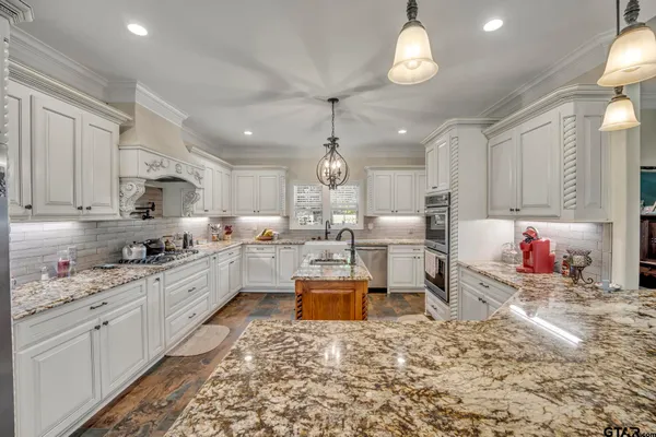 a kitchen with white cabinets and sink