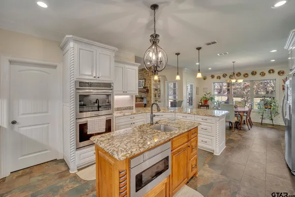 a kitchen with stainless steel appliances granite countertop a sink stove and refrigerator