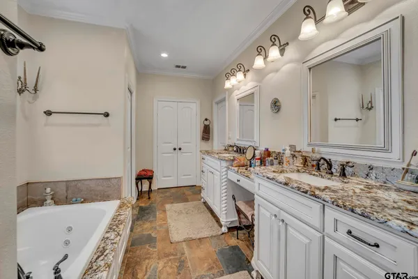 a bathroom with a tub sink and mirror
