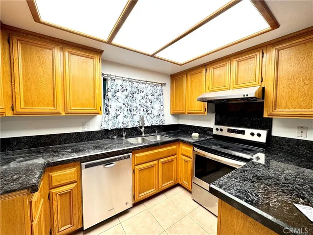a kitchen with stainless steel appliances granite countertop a sink a stove and a microwave