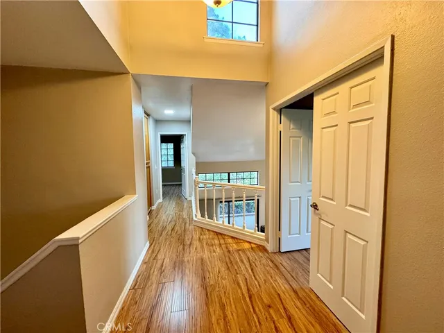 a view of a hallway with wooden floor and staircase