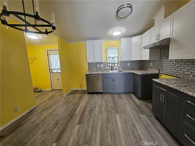 a kitchen with stainless steel appliances granite countertop a sink and wooden cabinets