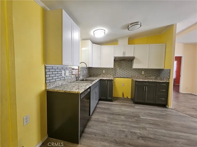 a kitchen with granite countertop a sink and a stove top oven
