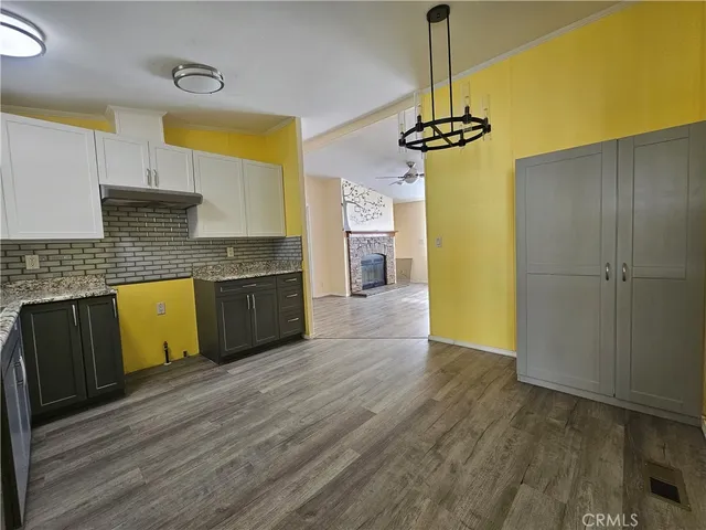 a kitchen with stainless steel appliances granite countertop a refrigerator a stove and a wooden floors