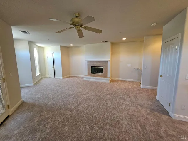 a view of an empty room and a ceiling fan