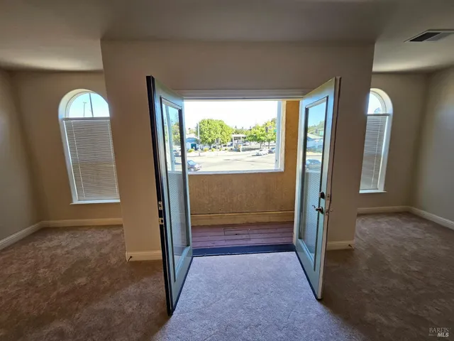 an empty room that has a large window and front door