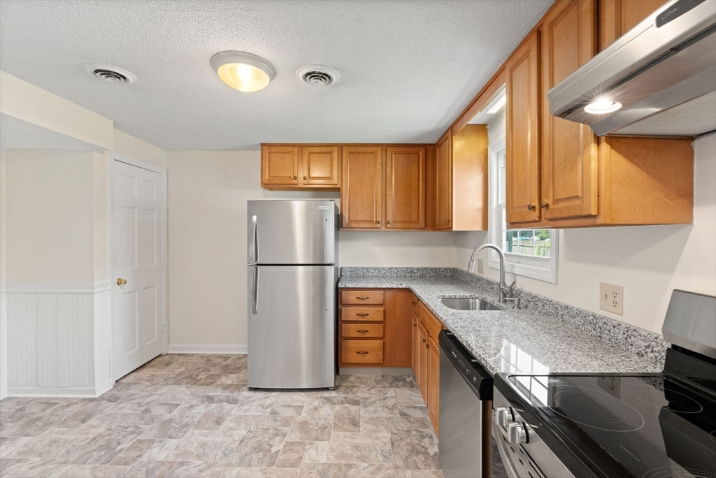 23 Constitution Way, Unit 23 Methuen, MA 01844 - Photo 7 of 21 a kitchen with stainless steel appliances granite countertop a refrigerator a sink and a stove