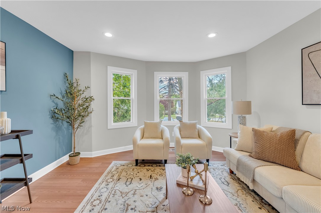 18155 Libby Road Maple Heights, OH 44137 - Photo 6 of 32 Living area featuring a bay window with three vertical windows, a distinct accent wall, recessed lighting, and wood-finish flooring