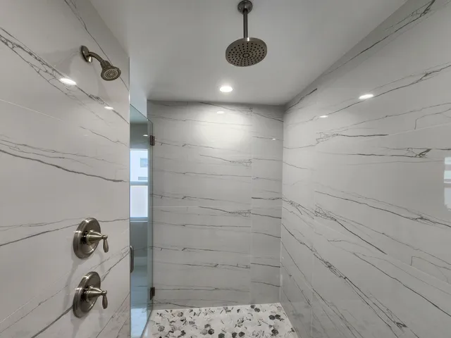 a bathroom with a double vanity sink a toilet and shower