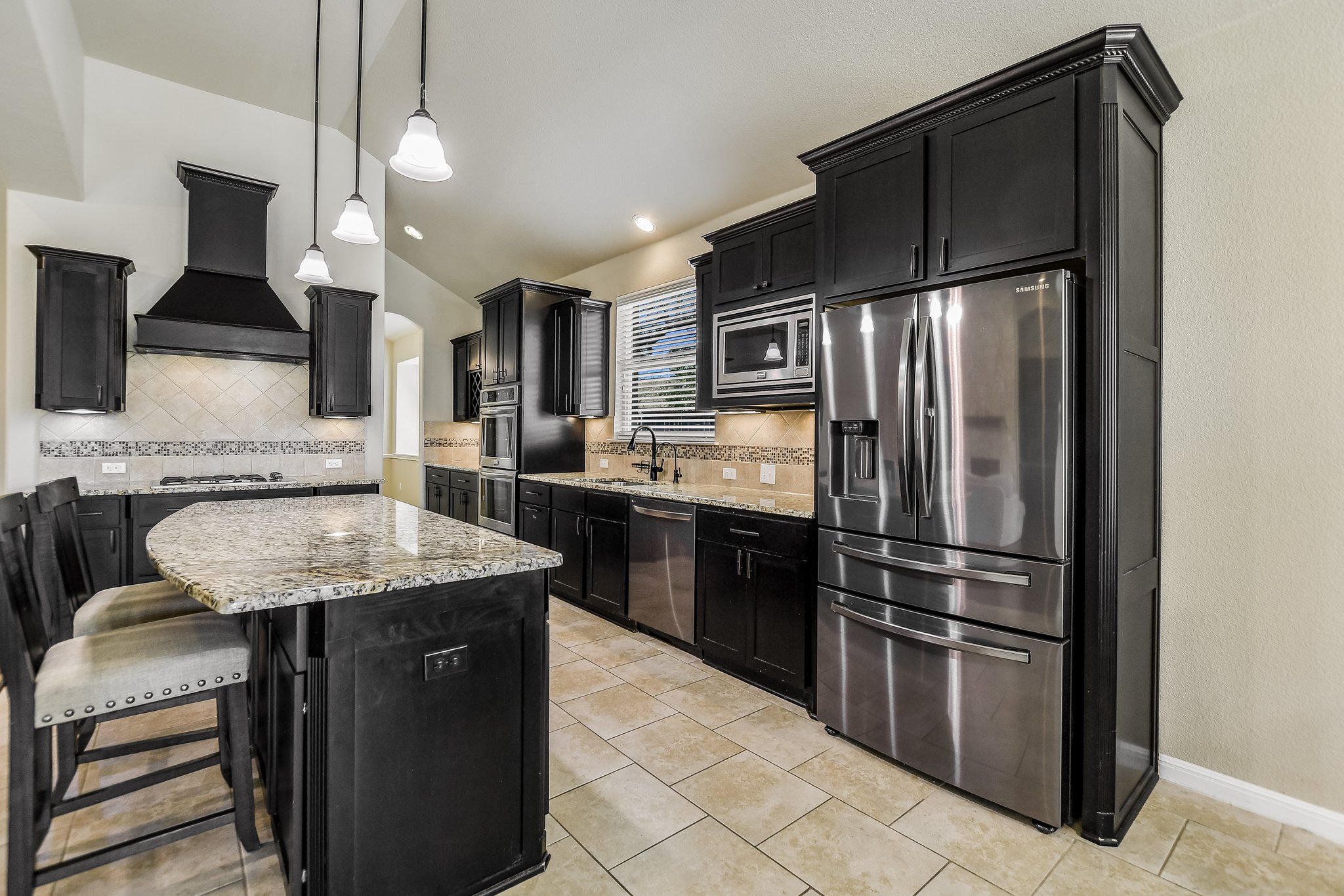 2037 Tribal Way Leander, TX 78641 - Photo 7 of 14 This kitchen has a butler's pantry, a walk-in pantry, double ovens, and a stylish vent hood