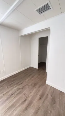 a view of an empty room with wooden floor