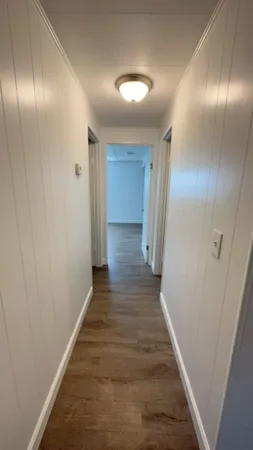a view of a hallway with wooden floor