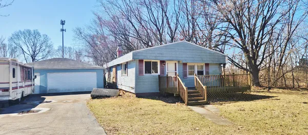 a front view of a house with a yard covered in snow