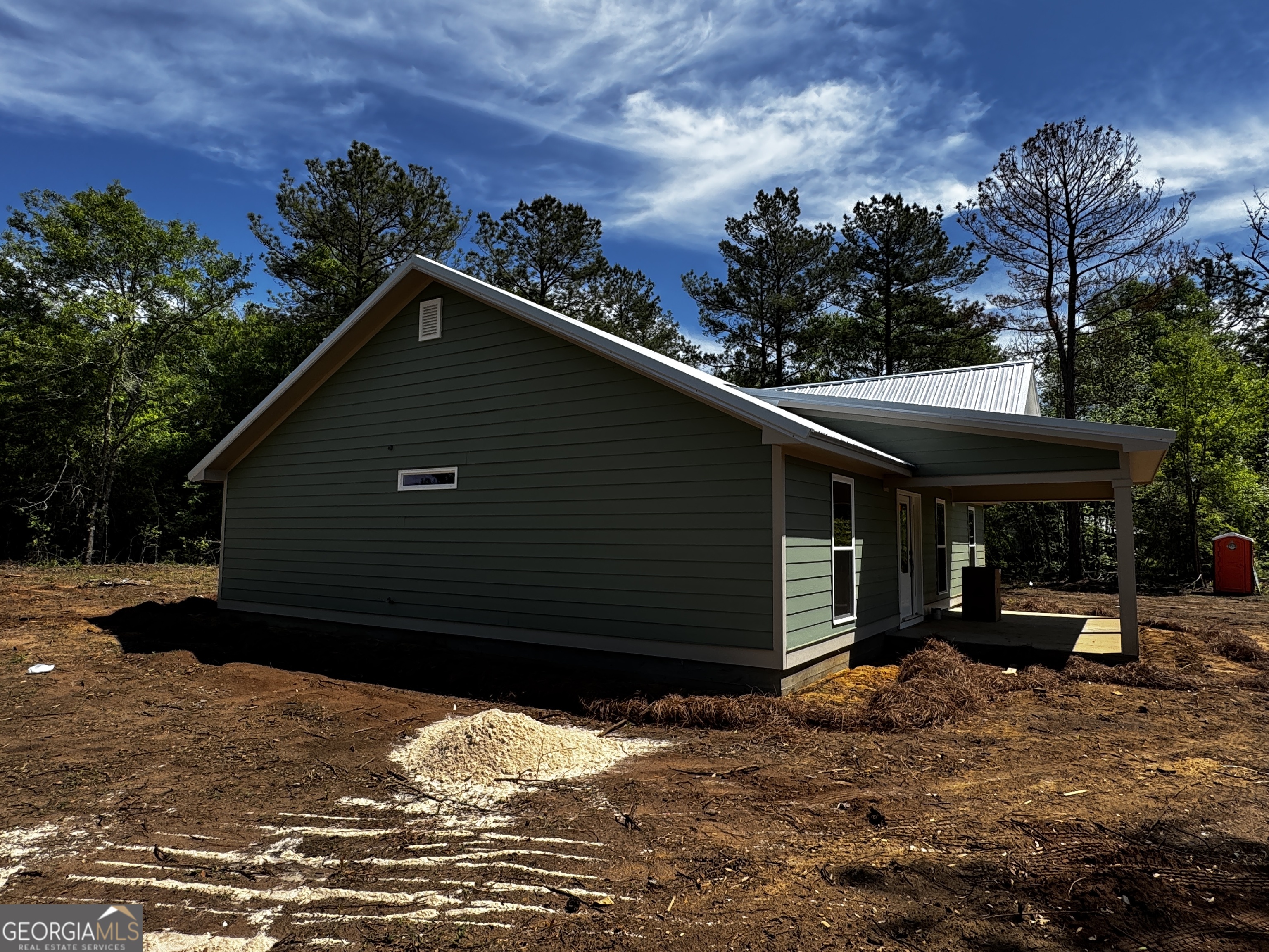 27 Bluegill Road Vienna, GA 31092 - Photo 55 of 68 a backyard of a house with table and chairs under an umbrella