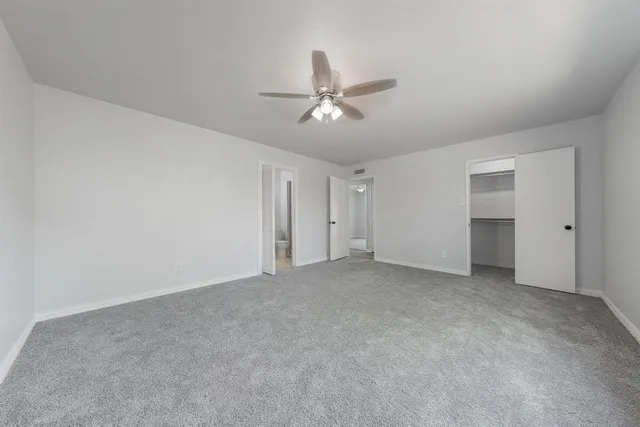a view of an empty room with a ceiling fan
