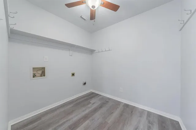 an empty room with a chandelier fan