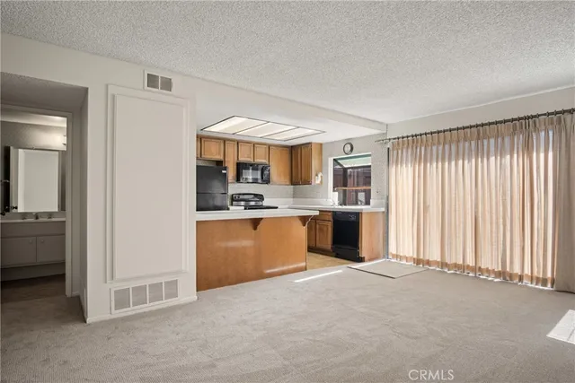 a view of a kitchen with refrigerator and cabinets