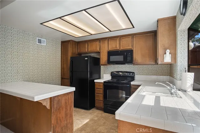 a kitchen with granite countertop a refrigerator and a stove top oven