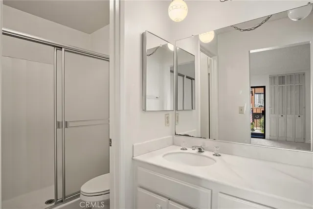 a bathroom with a granite countertop sink mirror vanity and toilet