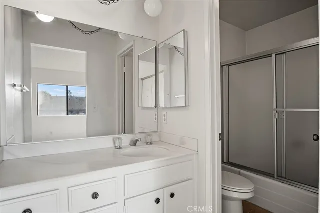 a bathroom with a granite countertop sink a toilet and shower
