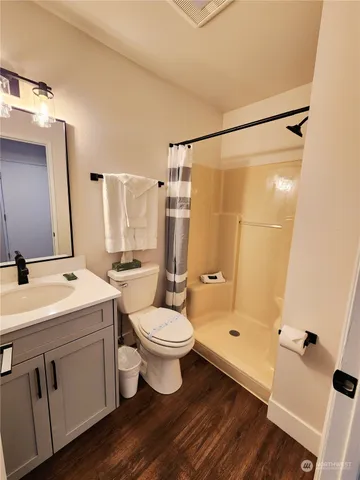 a bathroom with a double vanity sink toilet mirror and shower