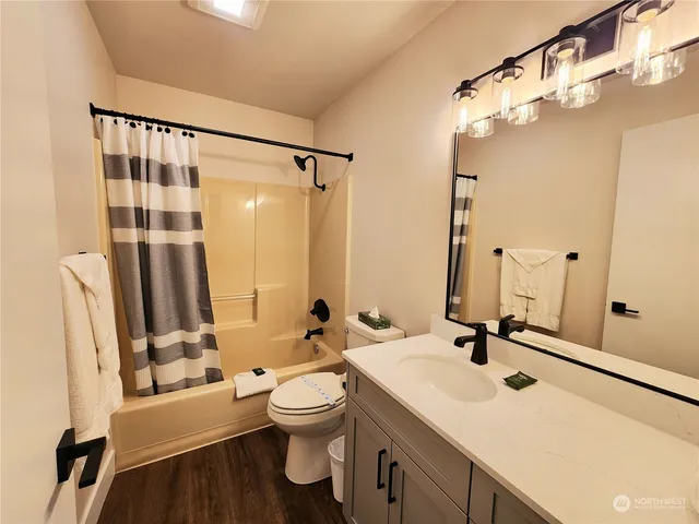 a bathroom with a sink toilet a mirror and shower