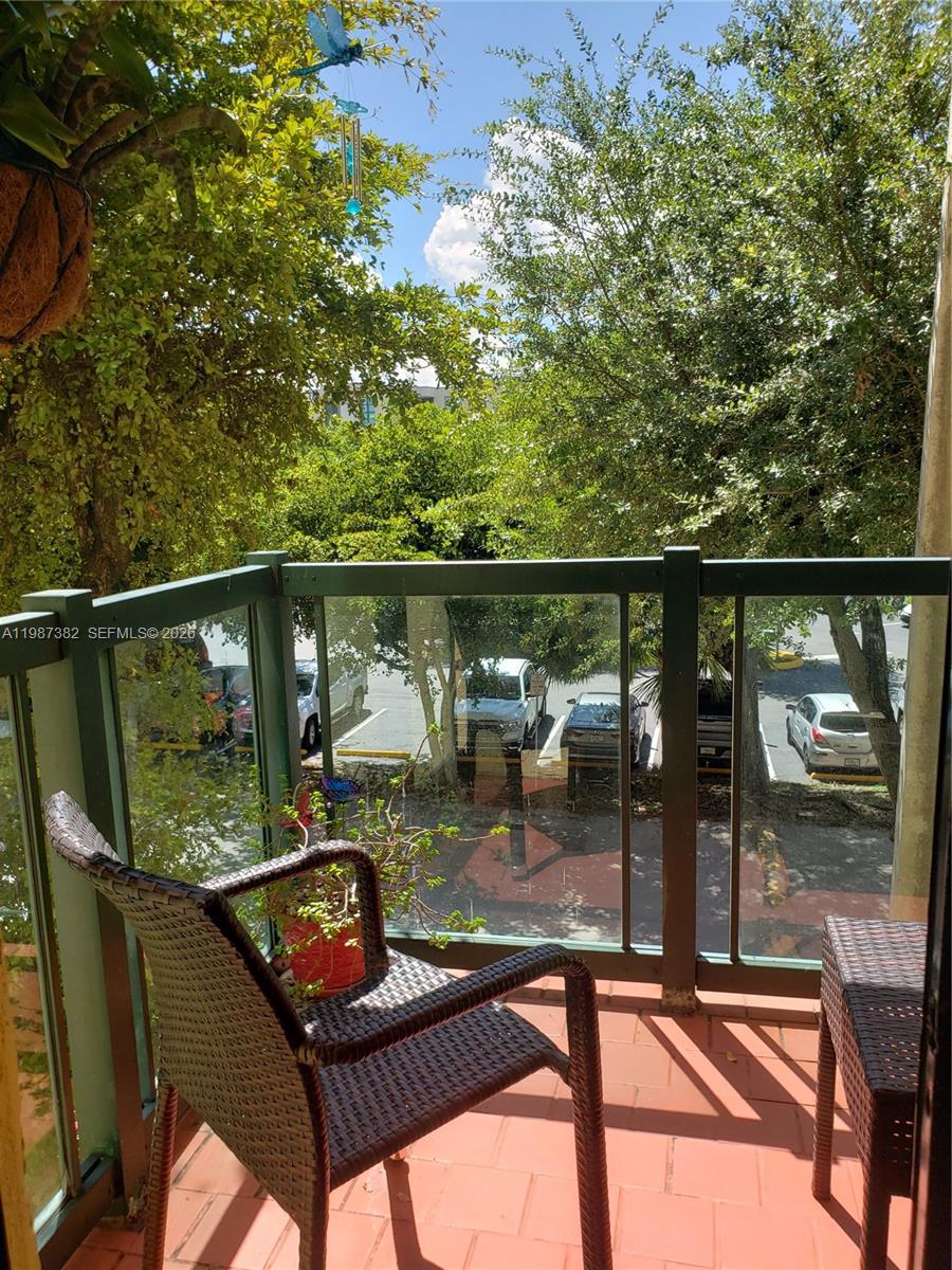11800 Southwest 18th Street, Unit 3274 Miami, FL 33175 - Photo 19 of 23 a balcony with wooden floor and outdoor seating
