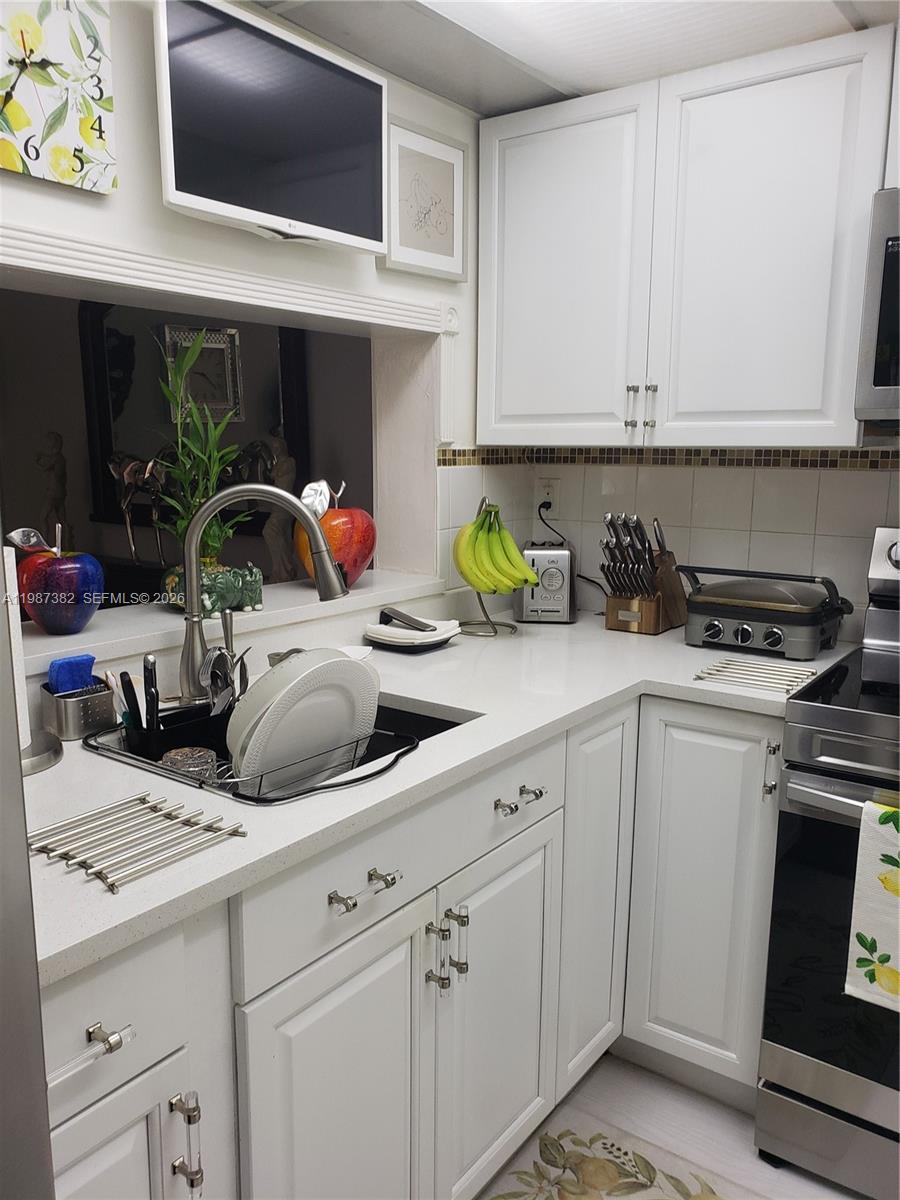11800 Southwest 18th Street, Unit 3274 Miami, FL 33175 - Photo 7 of 23 a kitchen with a sink a stove and cabinets