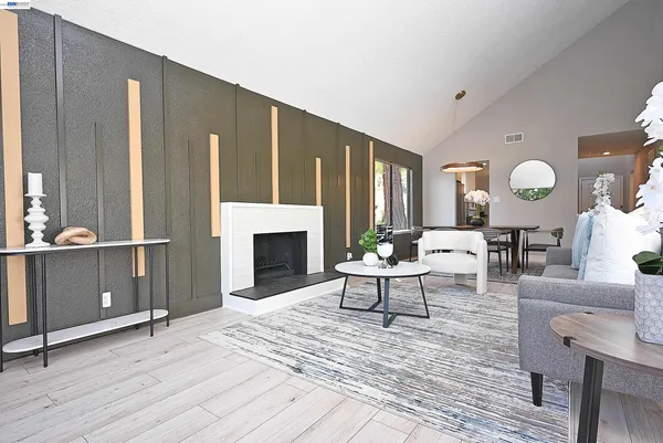 a living room with furniture a fireplace and a large window