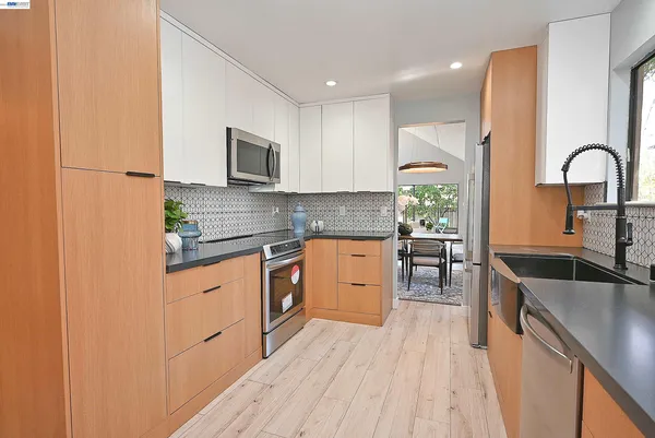 a kitchen with stainless steel appliances granite countertop a sink stove and refrigerator