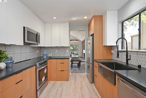 a kitchen with stainless steel appliances granite countertop a sink stove and refrigerator