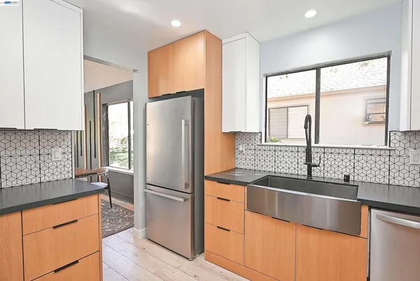 a kitchen with stainless steel appliances granite countertop a refrigerator and a sink