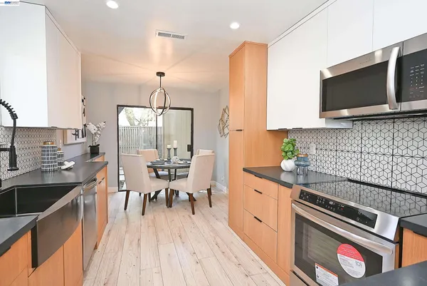 a kitchen with stainless steel appliances granite countertop a sink stove and microwave