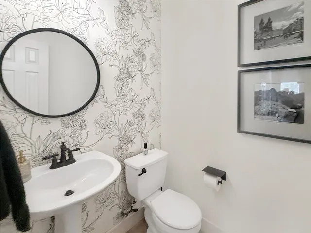 a bathroom with a sink mirror and toilet