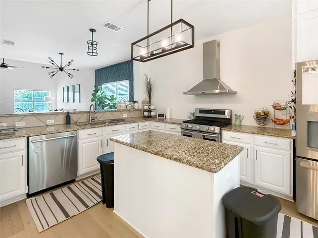 a kitchen with stainless steel appliances granite countertop a sink stove and refrigerator