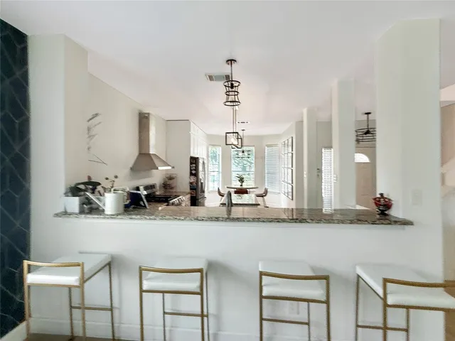 a dining hall with stainless steel appliances kitchen island granite countertop a sink and cabinets