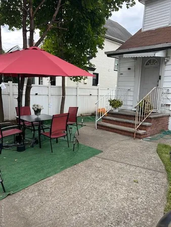 a patio with tables and chairs a fire pit and two lawn chairs