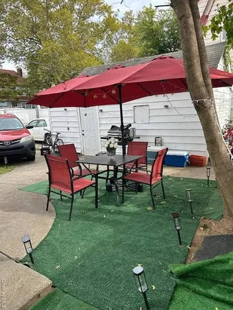 a view of a backyard with table and chairs under an umbrella