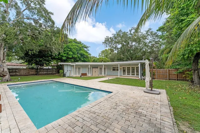a view of a house with swimming pool and yard