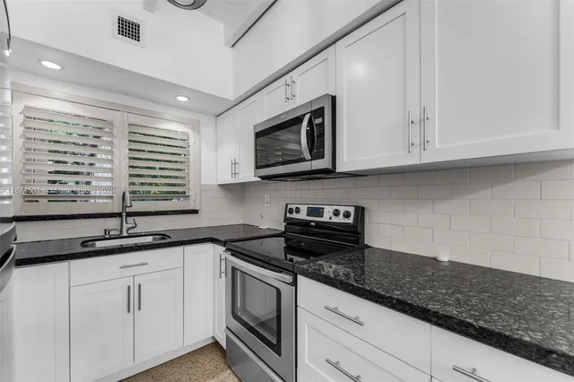 a kitchen with appliances cabinets and a counter top space