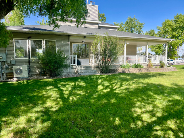 812 East Bates Cyn Road Tooele, UT 84074 - Photo 102 of 144 Expansive green lawn with a covered porch featuring white railings