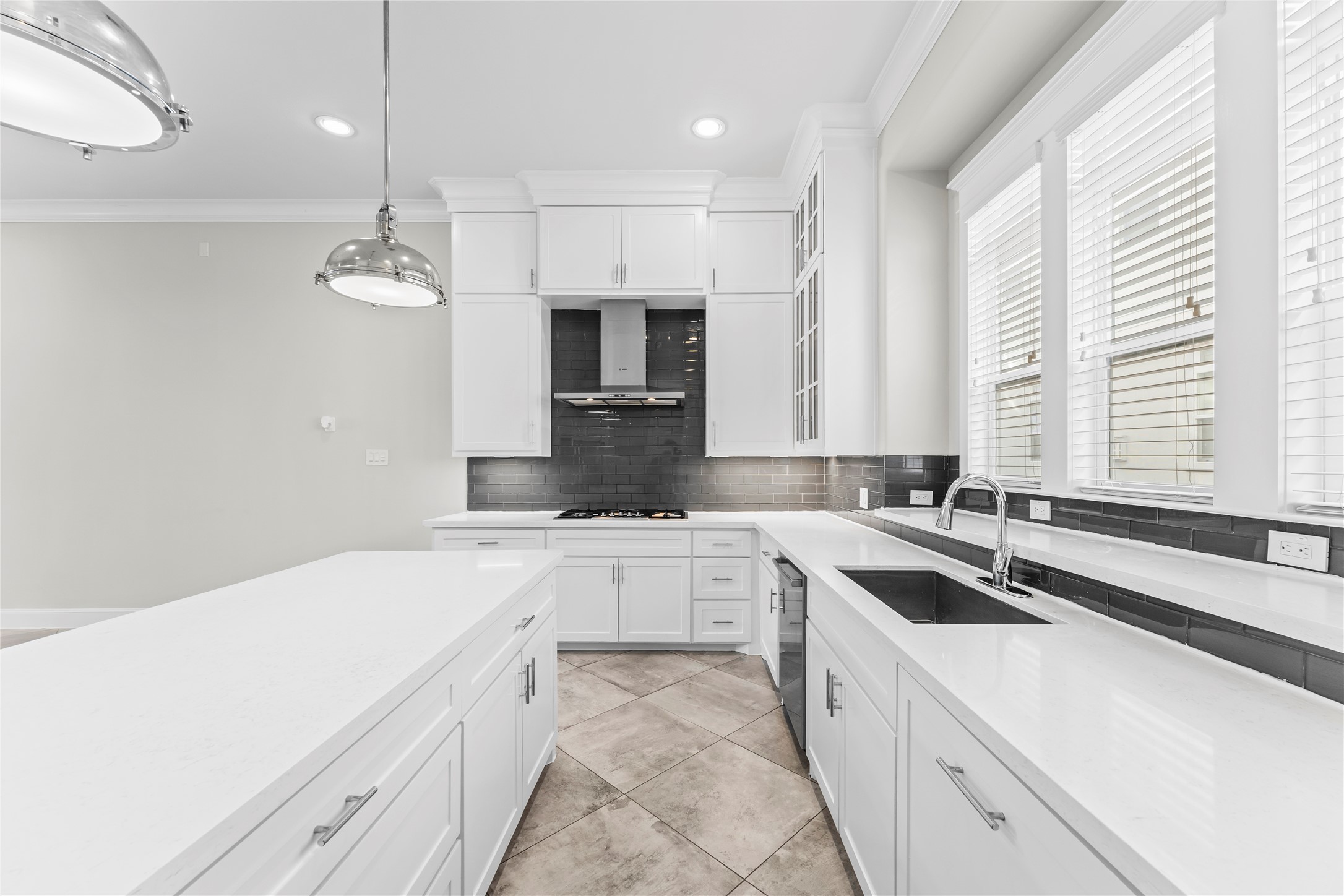 2806 Princeton Street Houston, TX 77009 - Photo 12 of 20 a large white kitchen with a sink and dishwasher a stove top oven with wooden floor